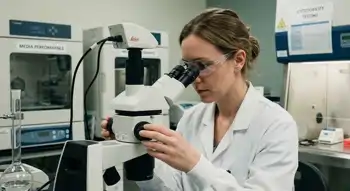 Woman looking through a microscope in a lab
